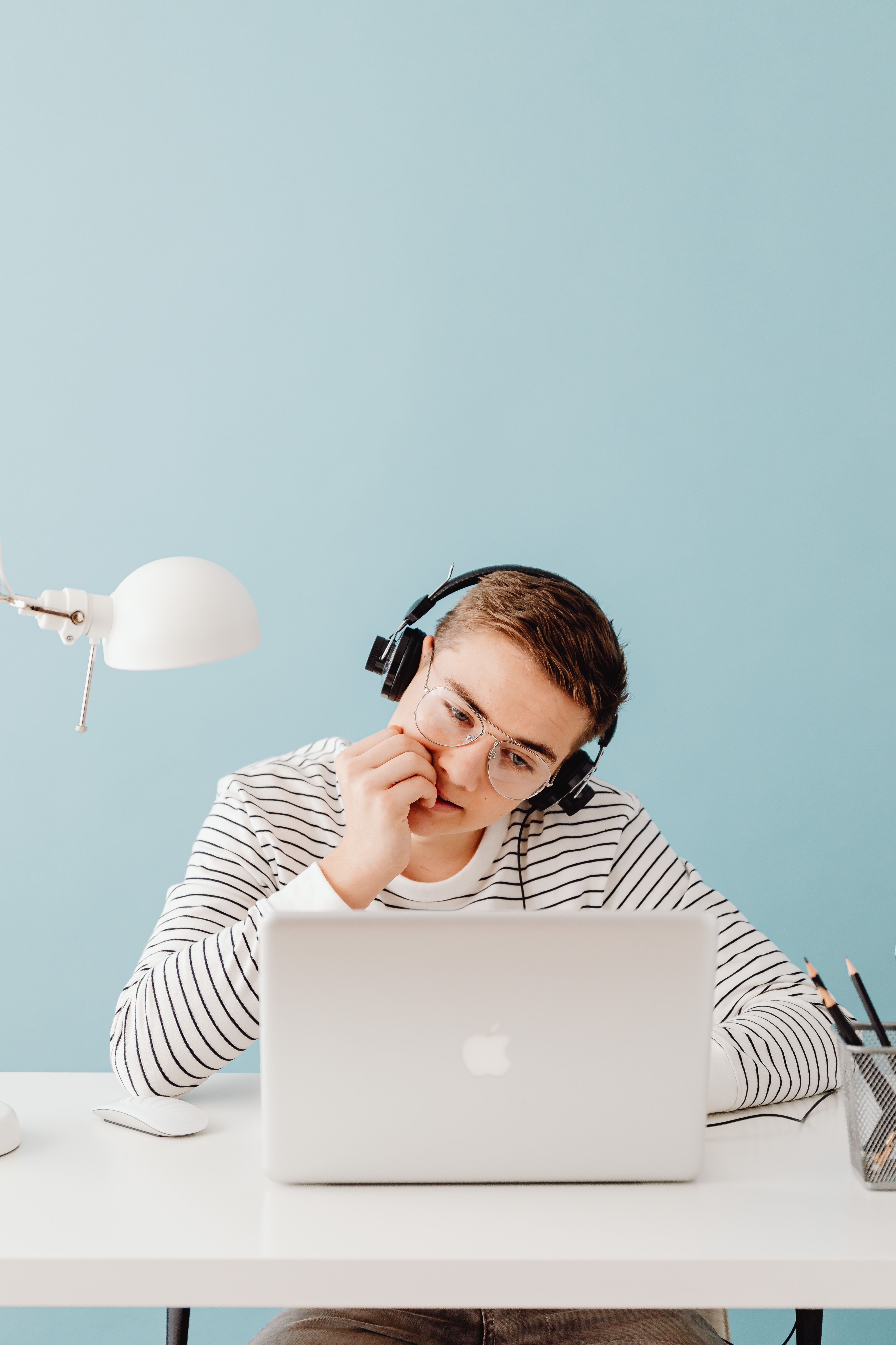 A learner wearing headphones while listening carefully during English practice.